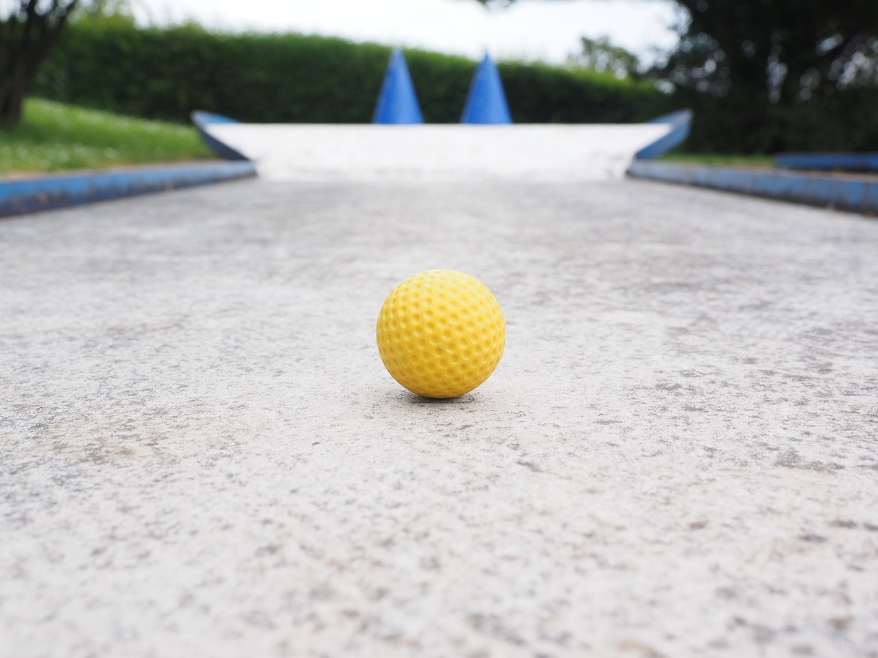 A yellow mini golf ball on the track